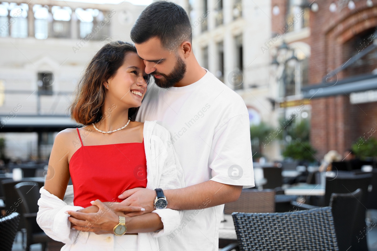 Photo of Happy young couple hugging on city street