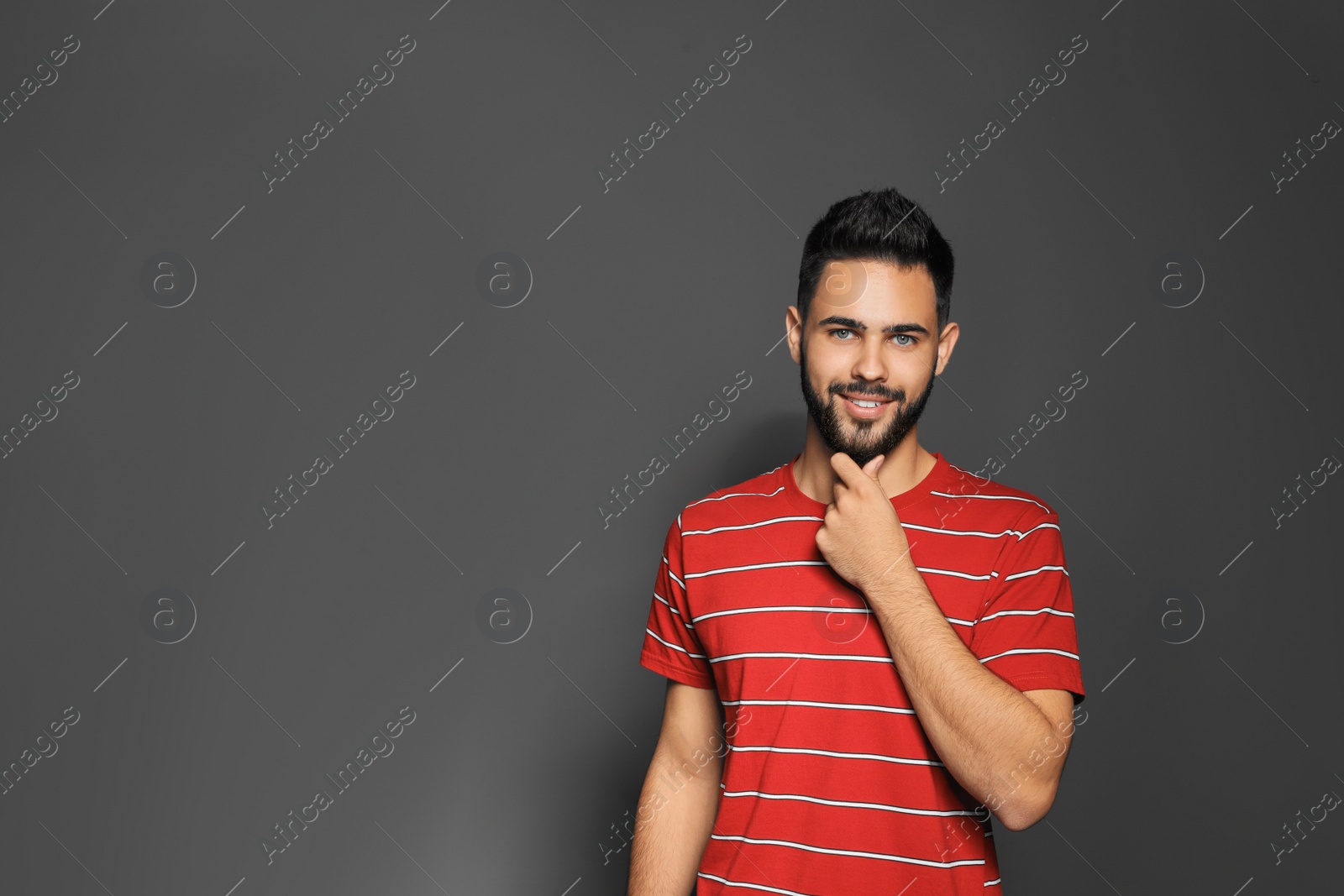 Photo of Portrait of handsome young man on gray background. Space for text