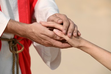 Photo of Jesus Christ holding woman's hand in desert, closeup