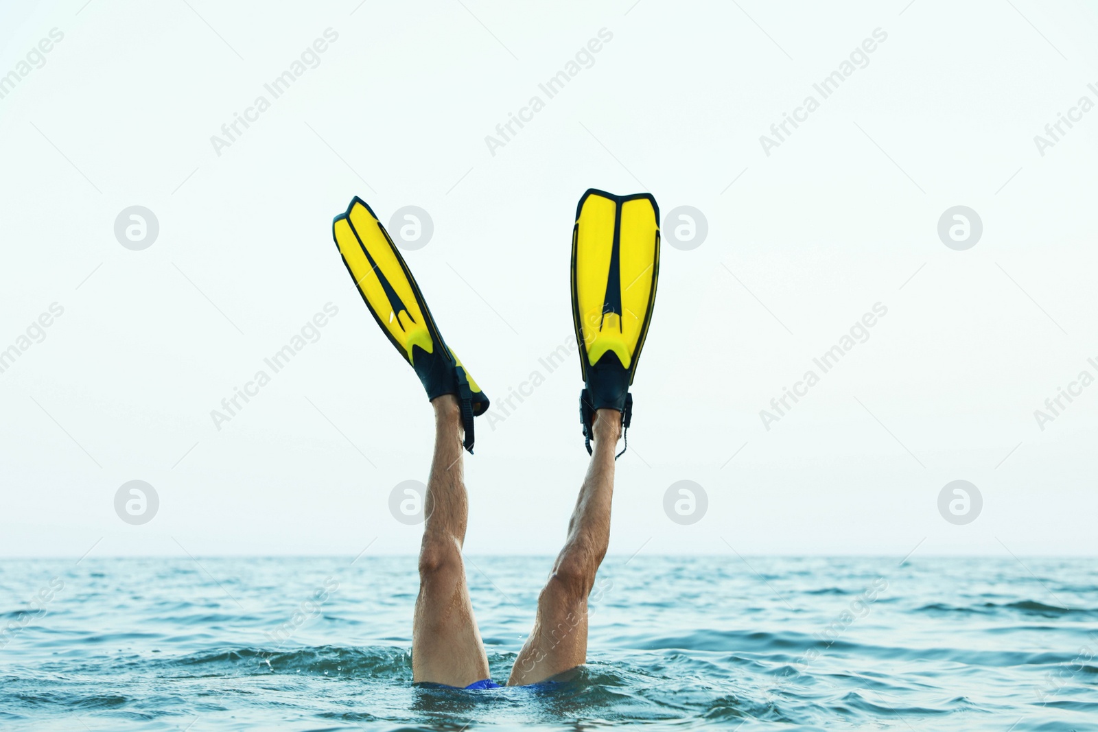 Photo of Man in flippers diving into sea water, closeup