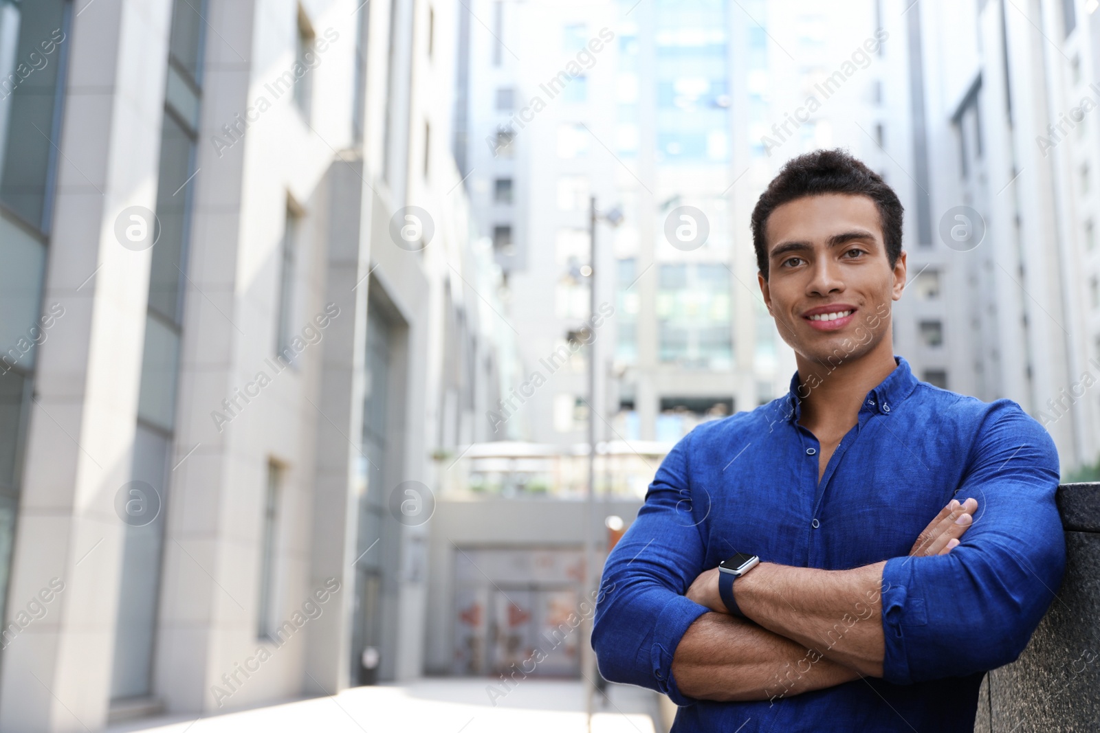 Photo of Handsome young African-American man on city street. Space for text