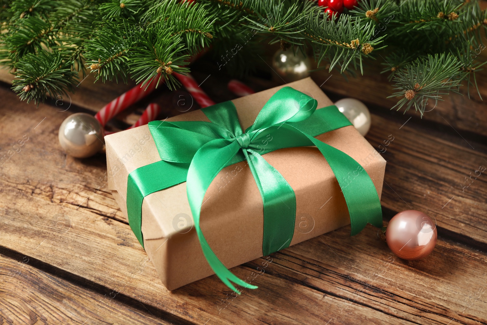 Photo of Christmas gift box and decor on wooden table, closeup