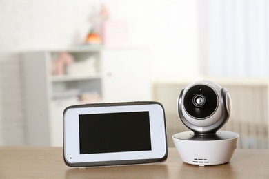 Photo of Baby monitor with camera on table in room. Video nanny
