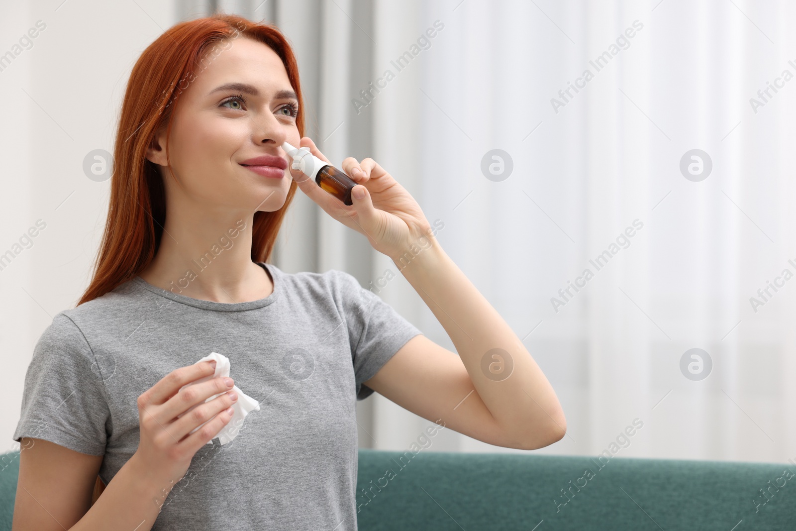 Photo of Medical drops. Woman with tissue using nasal spray at home, space for text