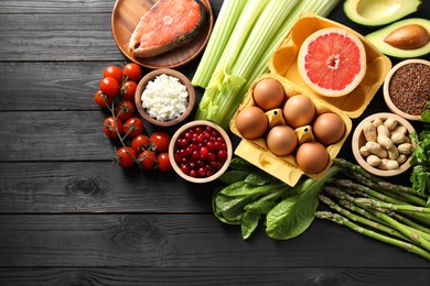 Photo of Many different healthy food on black wooden table, flat lay. Space for text