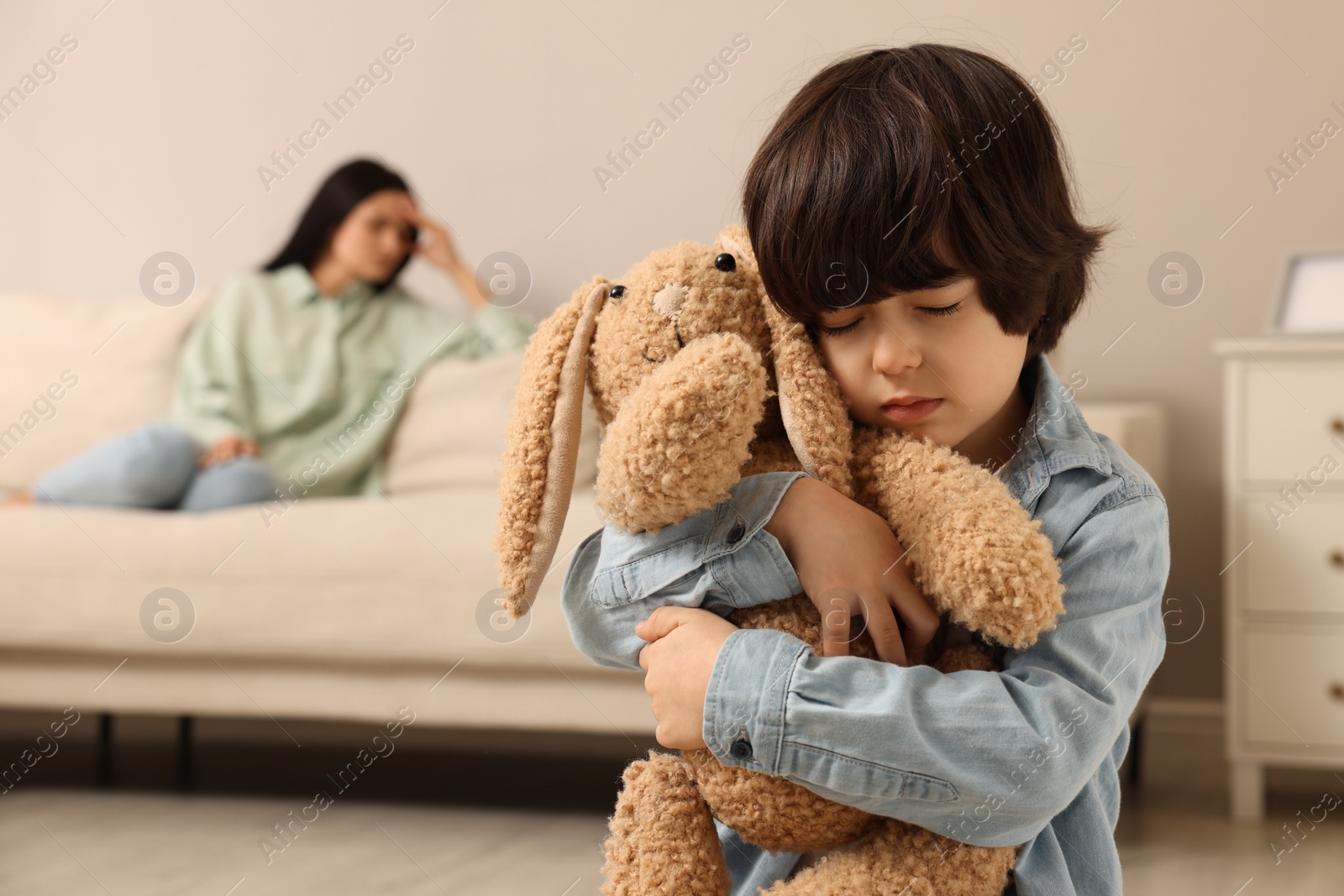 Photo of Upset child with toy bunny at home