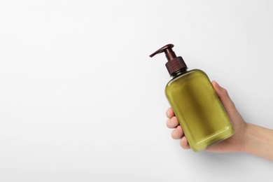 Photo of Woman holding shampoo bottle on white background, top view. Space for text