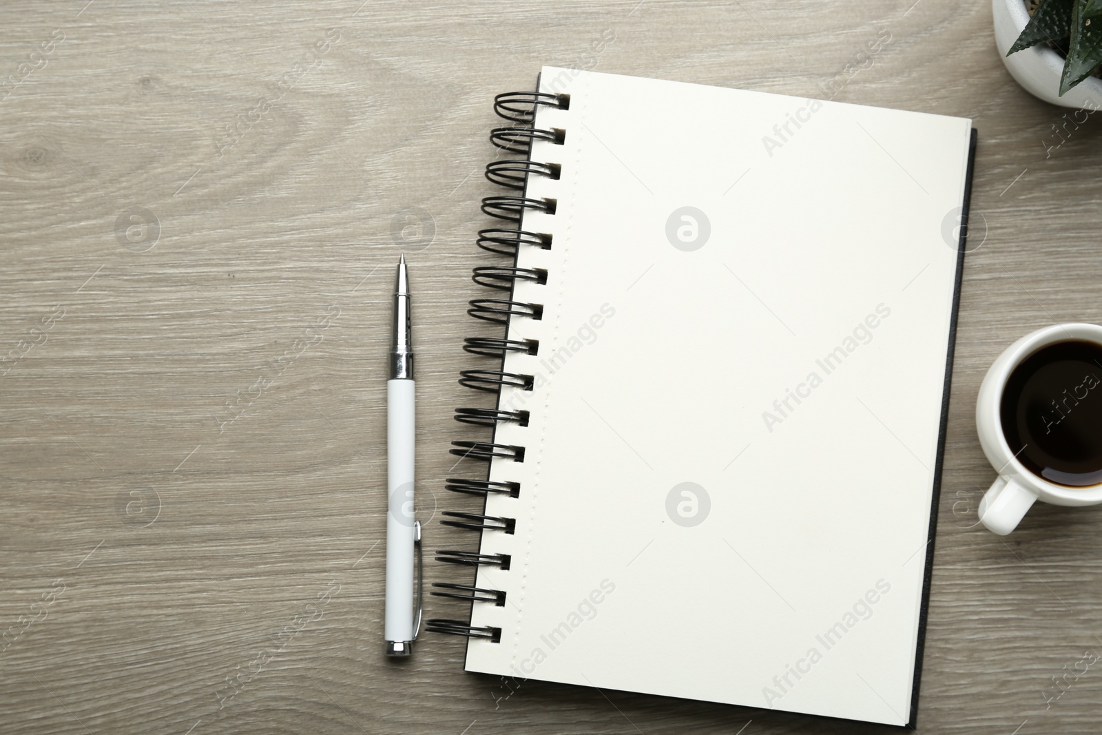 Photo of Flat lay composition with open notebook on light wooden table. Space for text