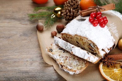 Traditional Christmas Stollen with icing sugar and cranberries on wooden table, space for text