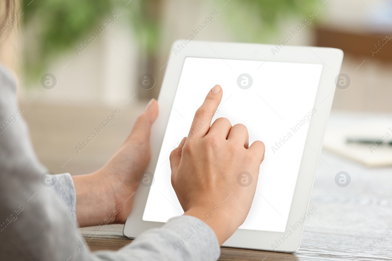 Photo of Young woman using new modern tablet in office, closeup