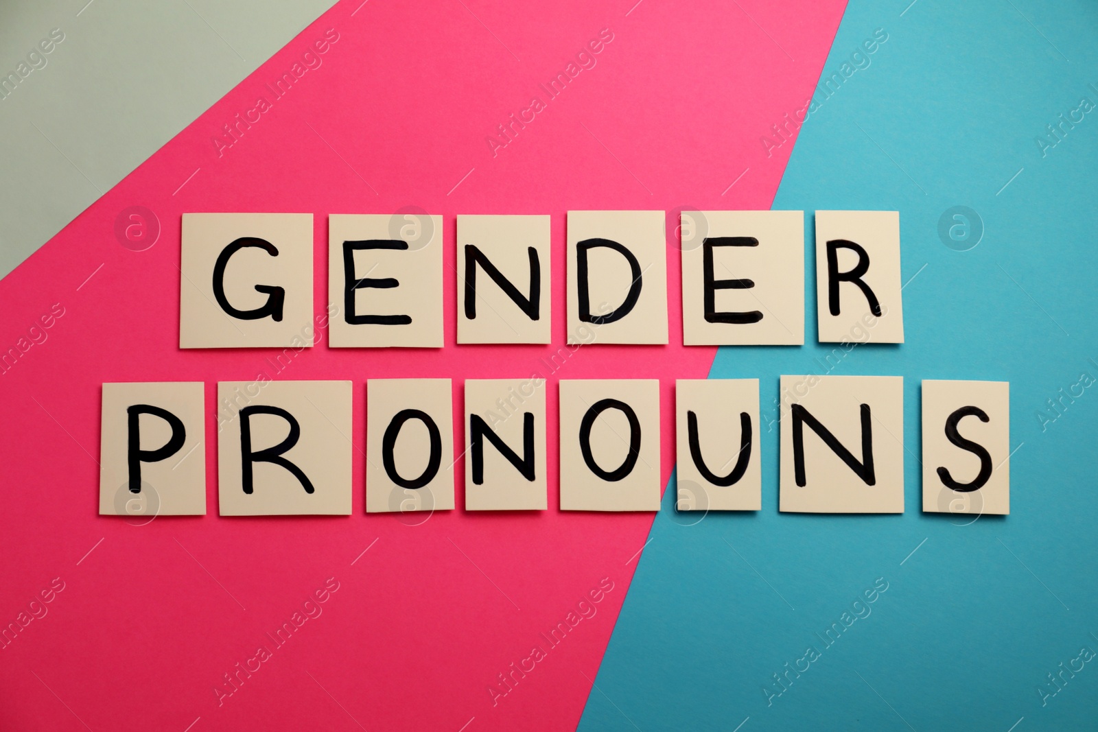 Photo of Paper notes with words Gender Pronouns on color background, flat lay