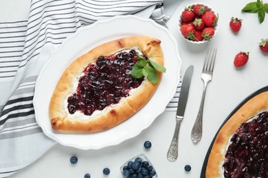 Photo of Delicious sweet cottage cheese pastry with cherry jam served on light table, flat lay