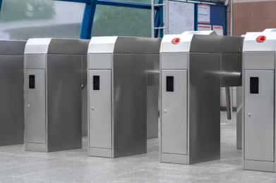 Photo of Many modern turnstiles outdoors. Fare collection system