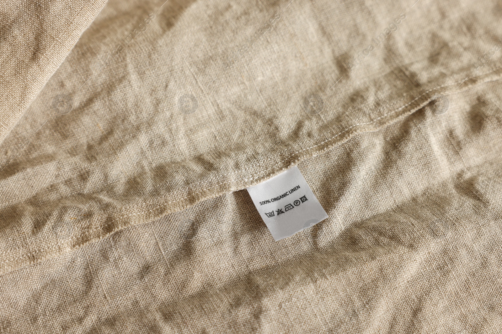 Photo of Clothing label on beige garment, closeup view