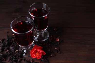 Photo of Delicious hibiscus tea on wooden table. Space for text
