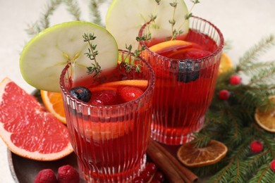 Photo of Aromatic Christmas Sangria in glasses served on table, closeup