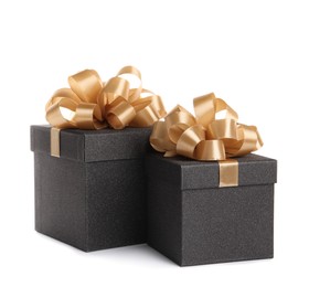 Black gift boxes with golden bows on white background