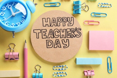 Cardboard with inscription HAPPY TEACHER'S DAY and stationery on color background