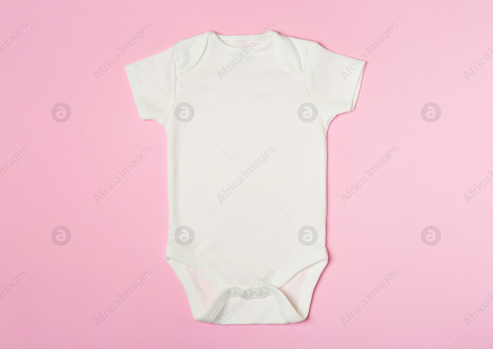 Photo of Cute baby onesie on color background, top view
