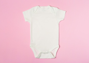 Photo of Cute baby onesie on color background, top view