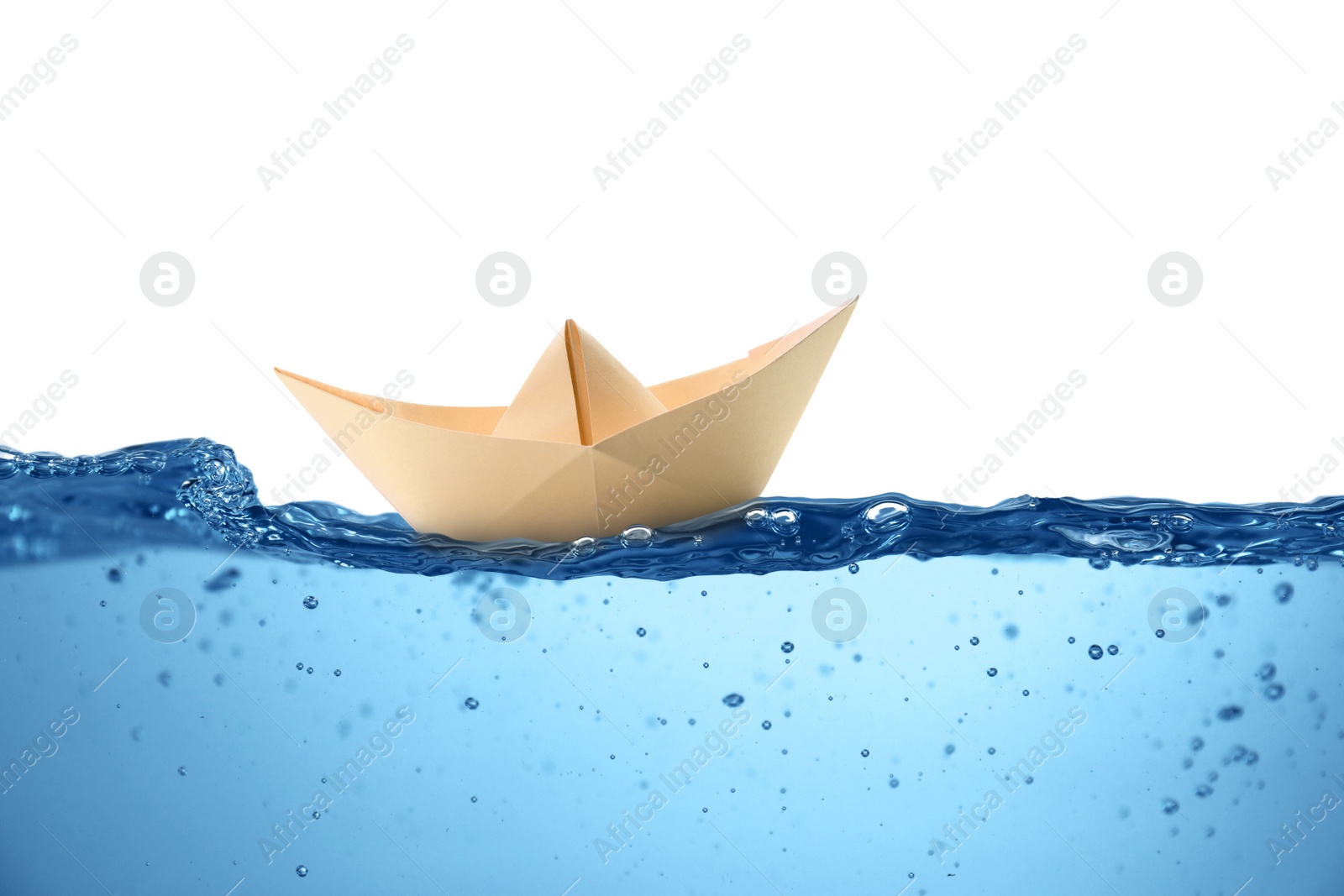 Image of Handmade beige paper boat floating on clear water against white background 
