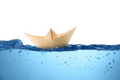 Image of Handmade beige paper boat floating on clear water against white background 