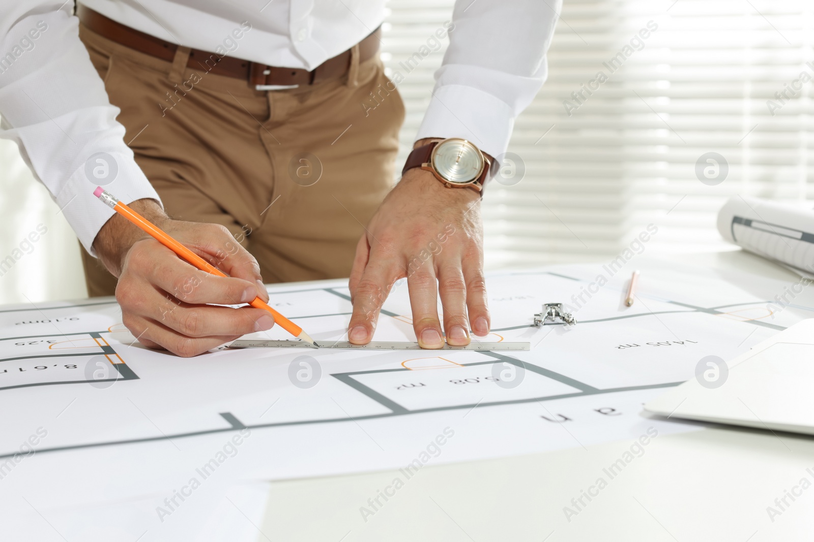 Photo of Architect working with construction drawings in office, closeup