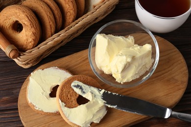Photo of Tasty homemade butter, cookies and tea on wooden table, flat lay