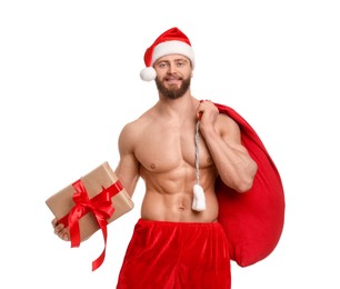Photo of Attractive young man with muscular body in Santa hat holding bag and Christmas gift box on white background