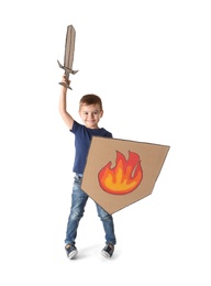 Photo of Cute little boy playing with cardboard sword and shield on white background