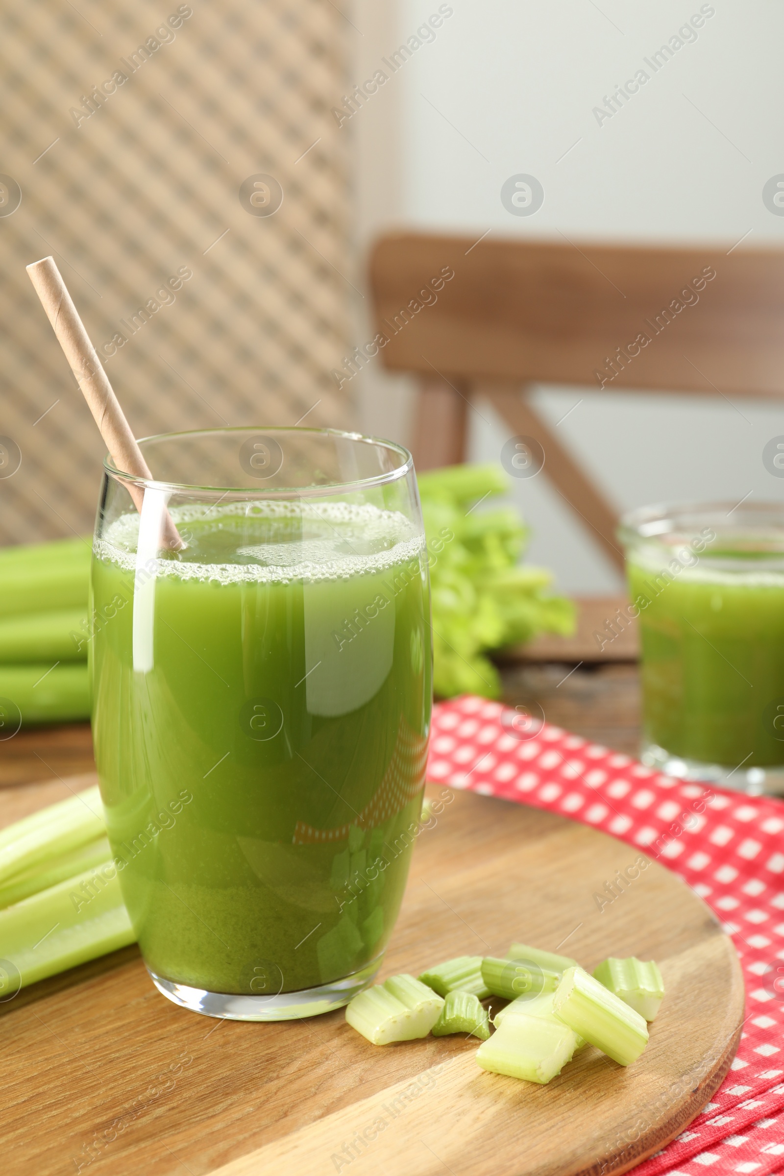 Photo of Glass of delicious celery juice and vegetables on table, closeup