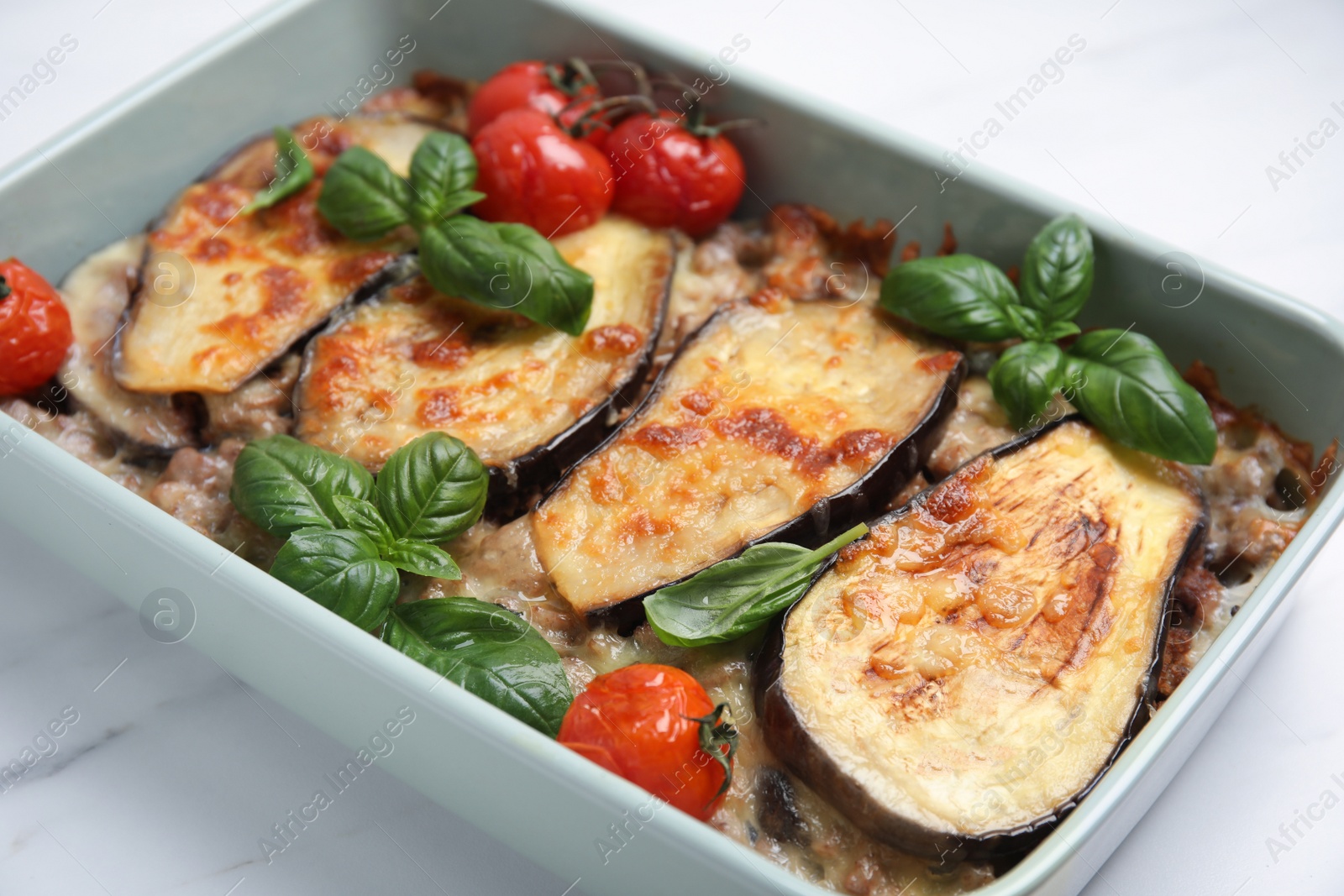 Photo of Delicious eggplant lasagna in baking dish on white marble table, closeup