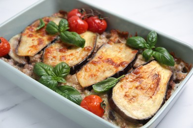 Photo of Delicious eggplant lasagna in baking dish on white marble table, closeup