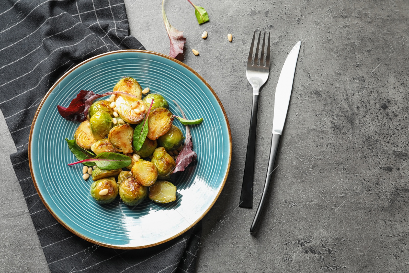 Photo of Salad with Brussels sprouts served on grey table, top view. Space for text