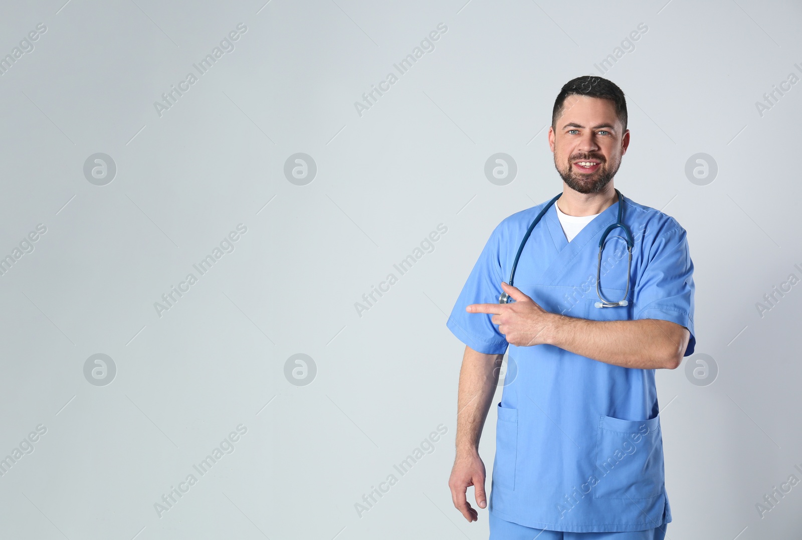 Photo of Portrait of mature doctor against light background