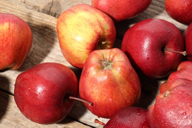 Photo of Many fresh apples with water drops on wooden table, above view