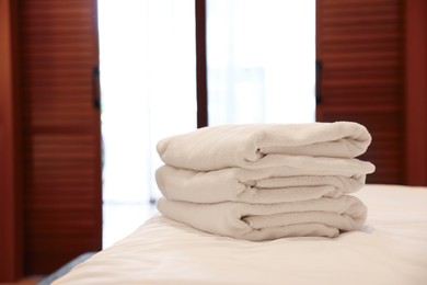 Photo of Stacked towels on bed in hotel room, space for text