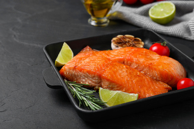 Photo of Delicious roasted fish served on black table