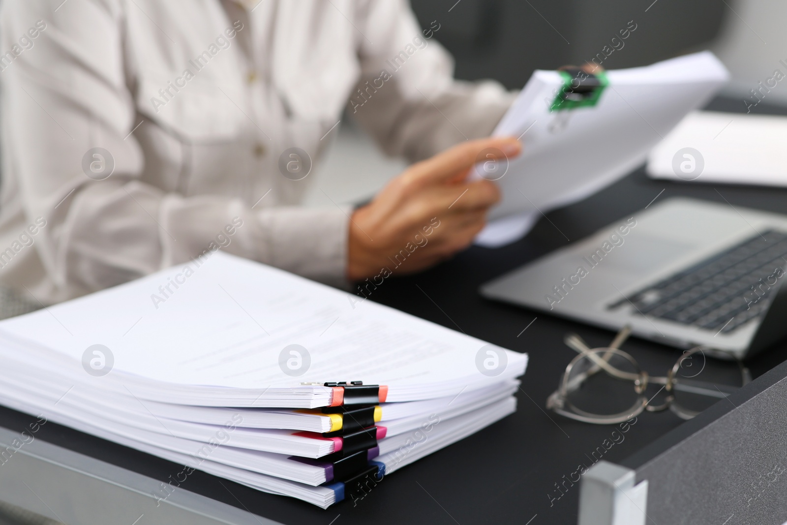 Photo of Businesswoman working at table in office, focus on documents. Space for text