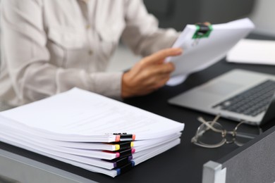 Businesswoman working at table in office, focus on documents. Space for text