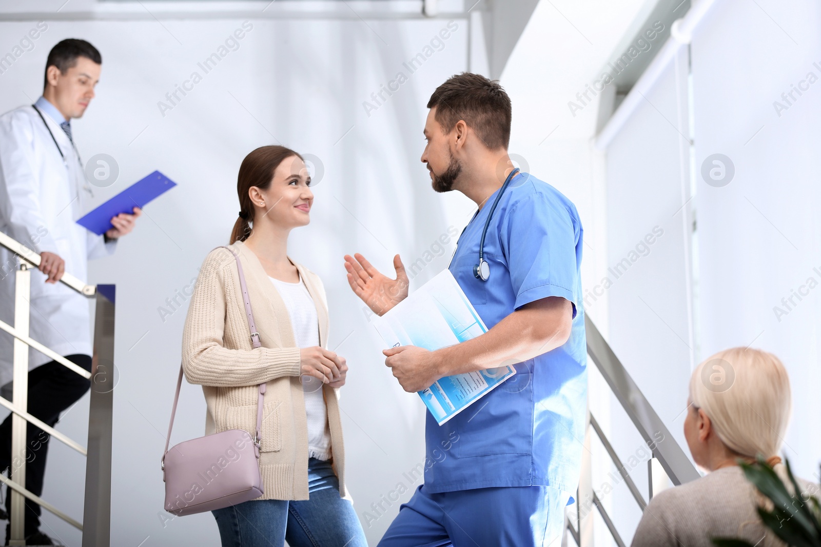 Photo of Doctor and patient discussing diagnosis on stairs in hospital