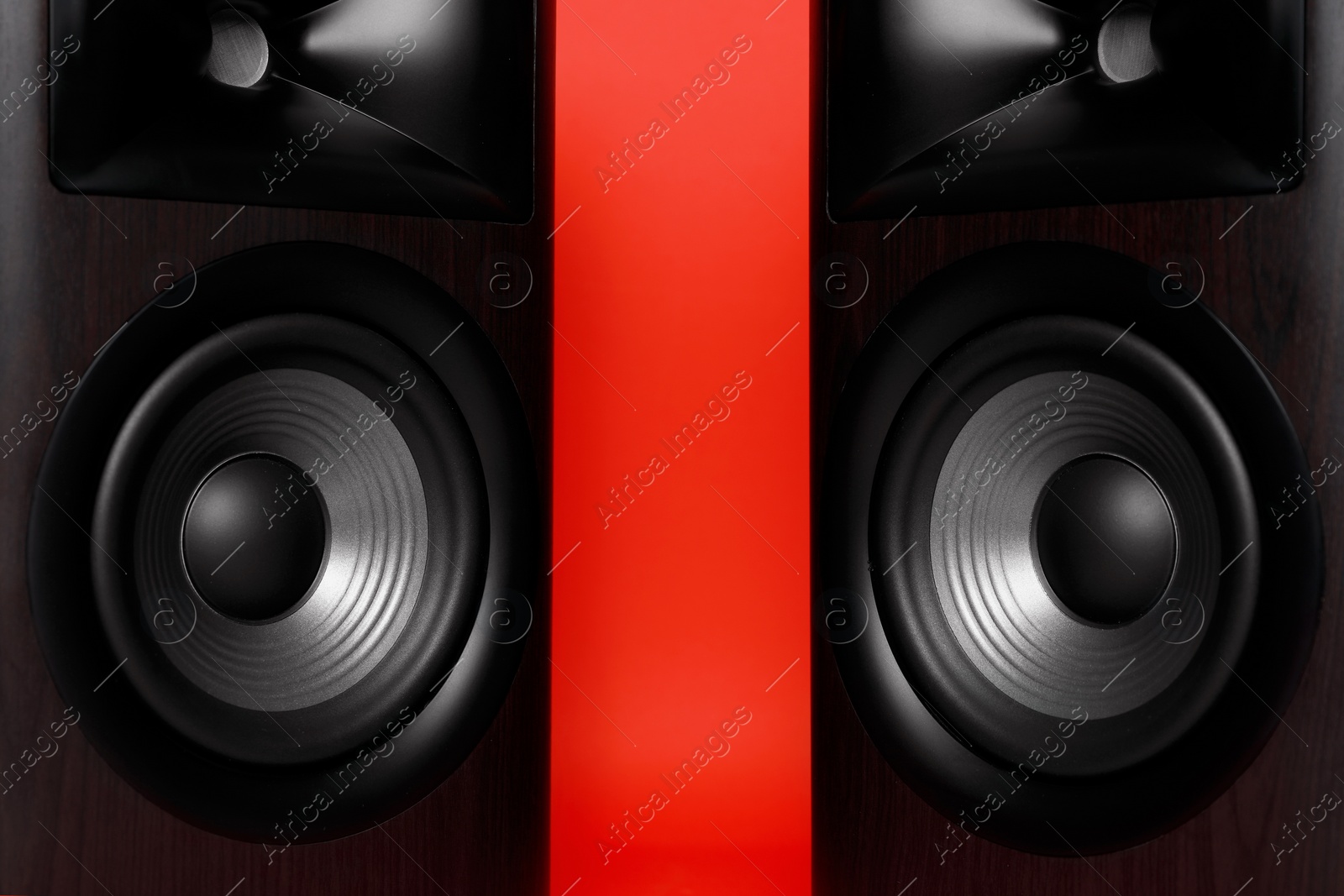 Photo of Modern wooden sound speakers on red background, closeup