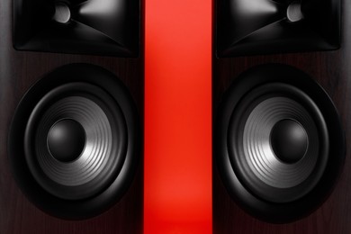 Photo of Modern wooden sound speakers on red background, closeup