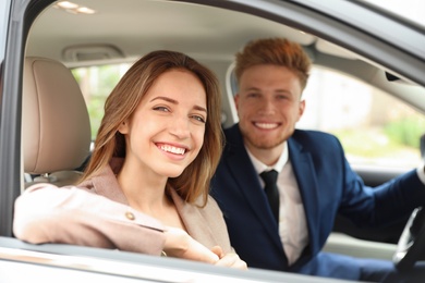 Photo of Happy young man and woman in modern car