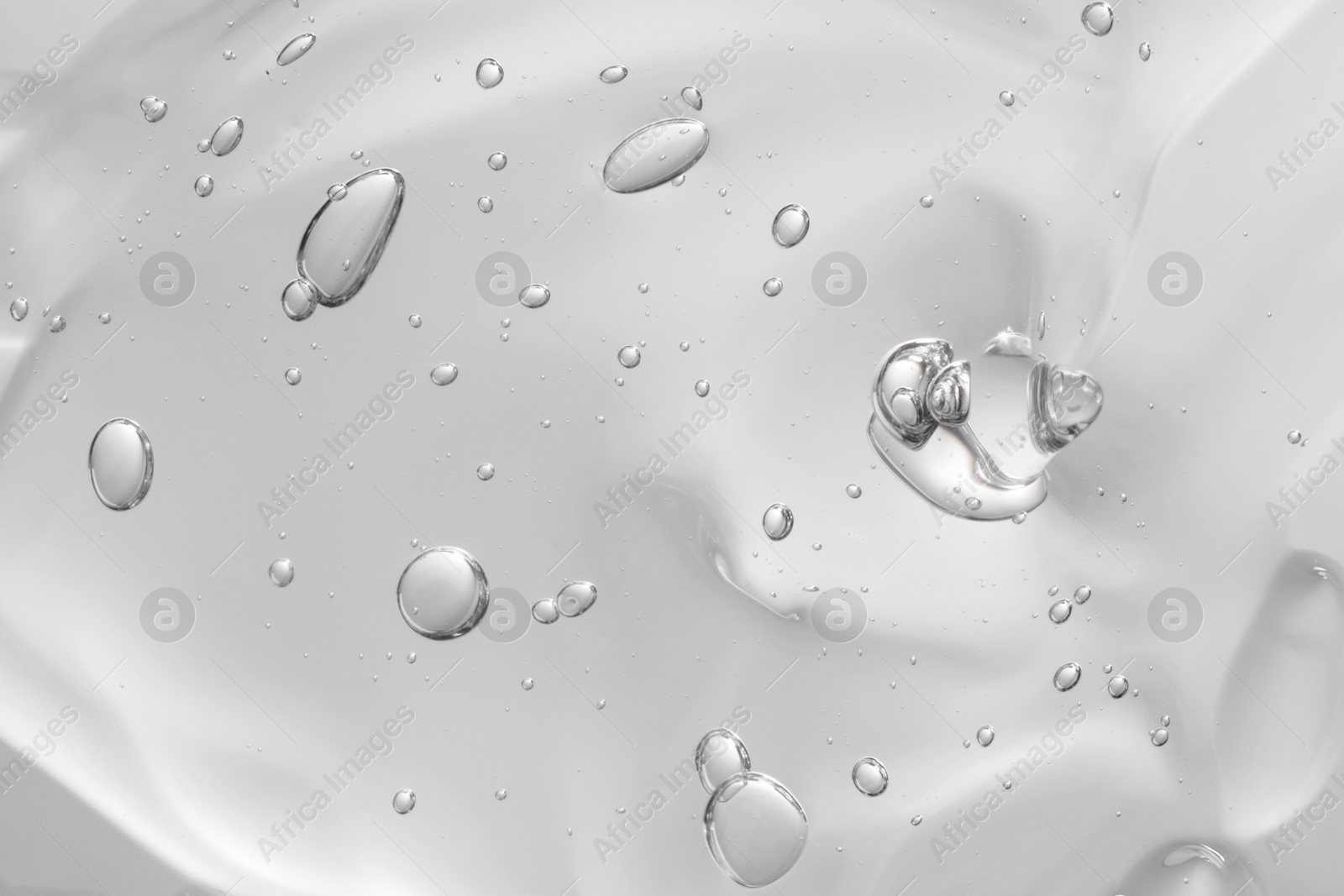Photo of Transparent cleansing gel on light grey background, closeup. Cosmetic product