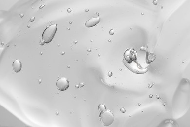 Transparent cleansing gel on light grey background, closeup. Cosmetic product