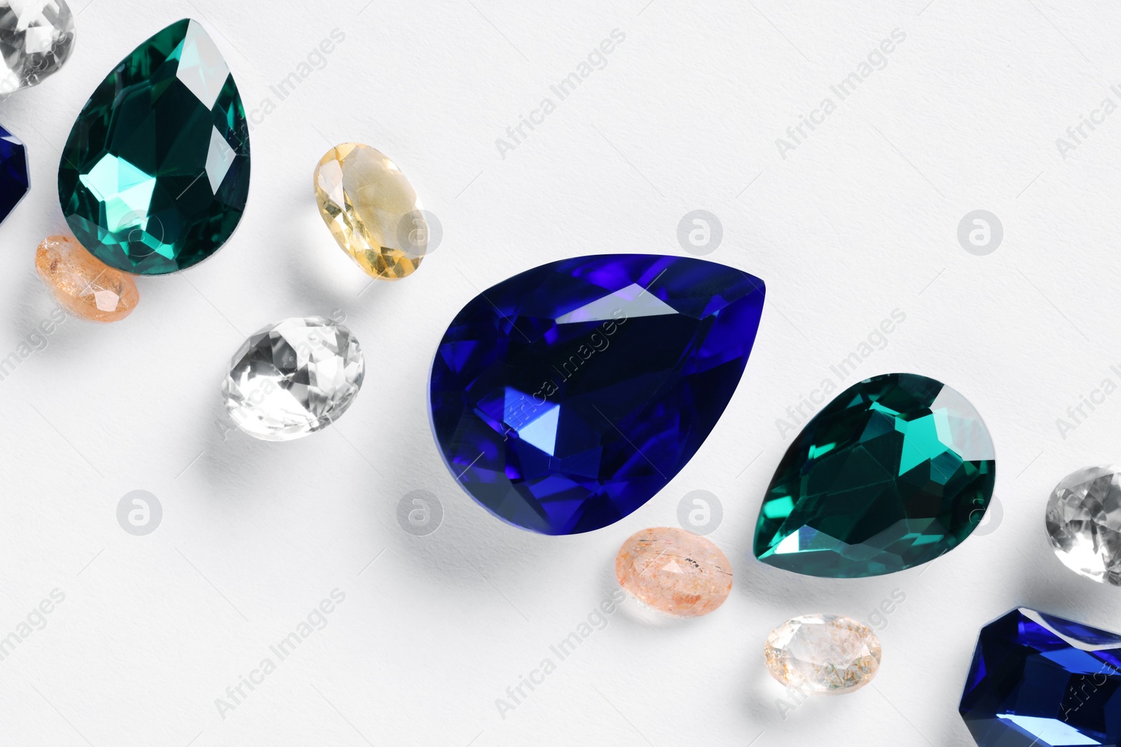 Photo of Different beautiful gemstones for jewelry on white background, top view
