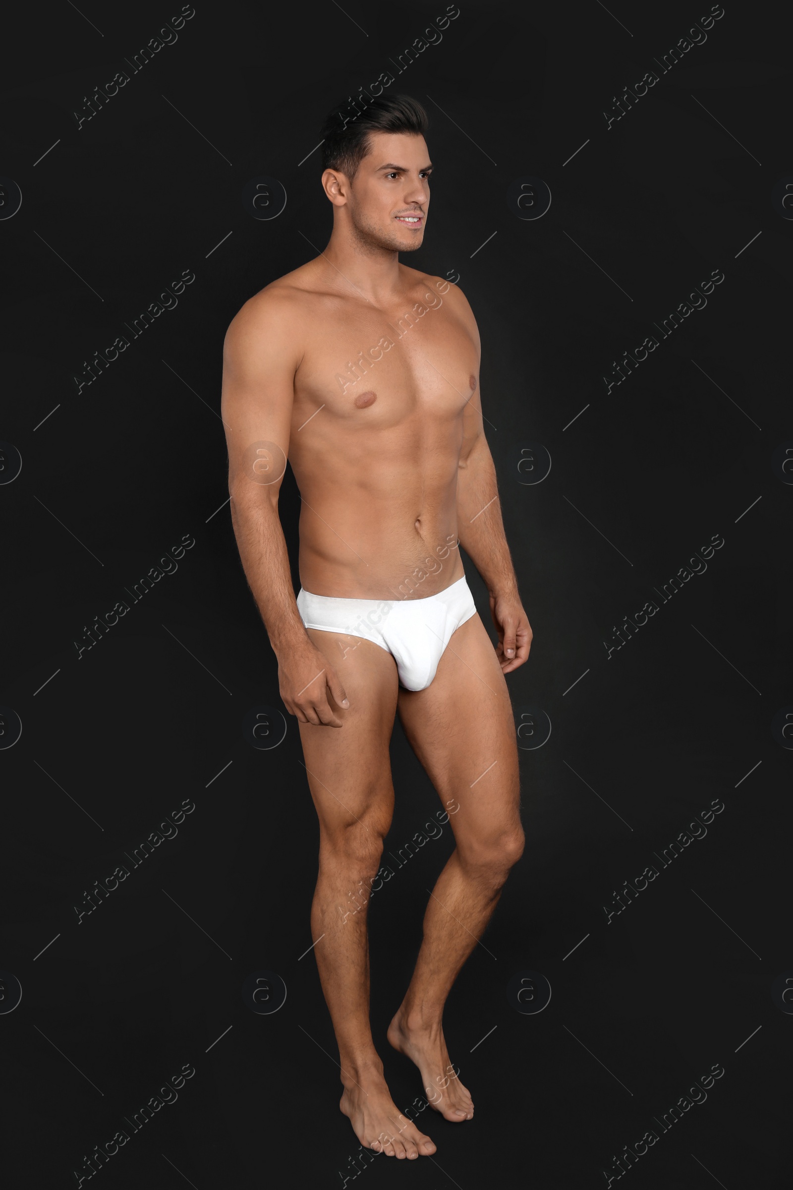 Photo of Handsome man in underwear on black background