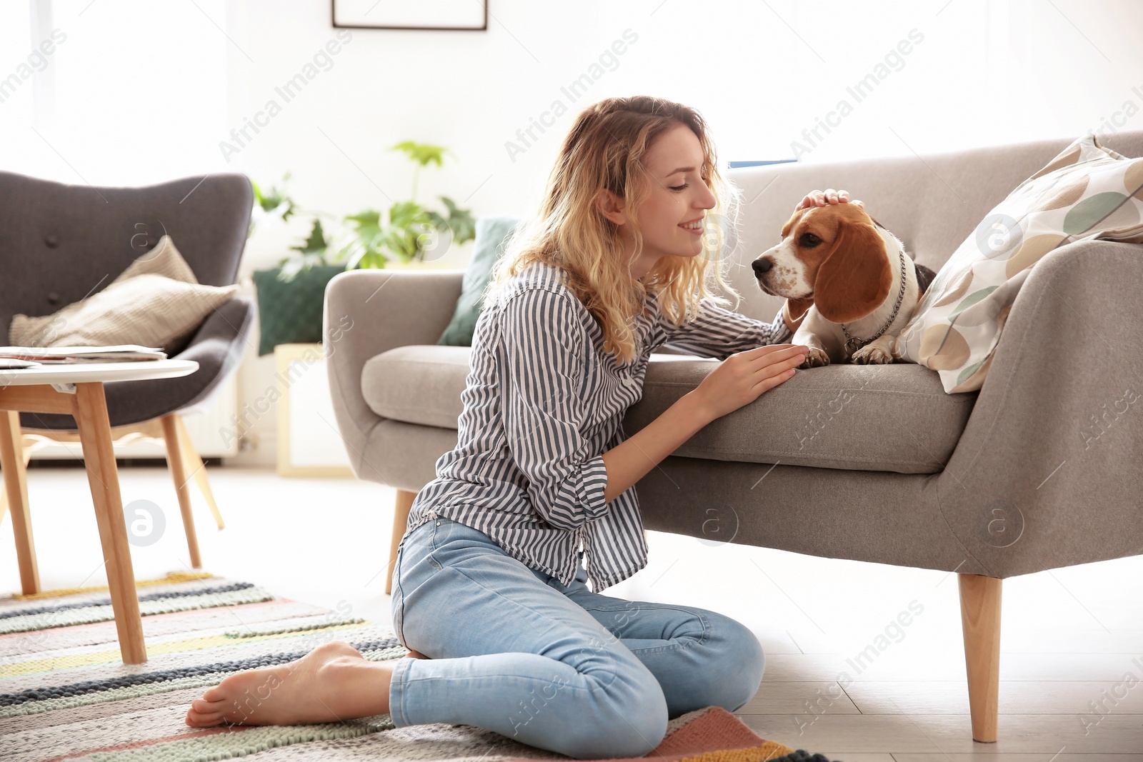 Photo of Young woman with her dog at home