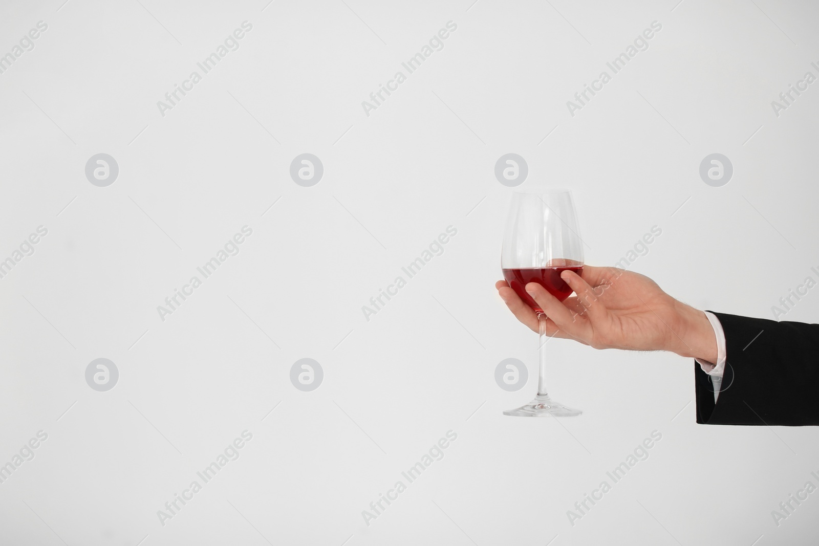 Photo of Man holding glass of wine on light background